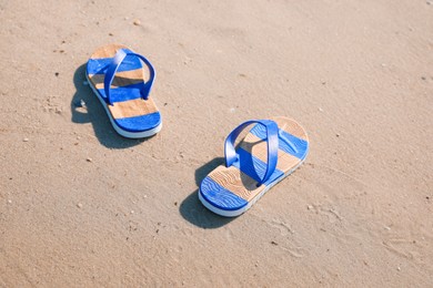 Pair of stylish flip flops on beach