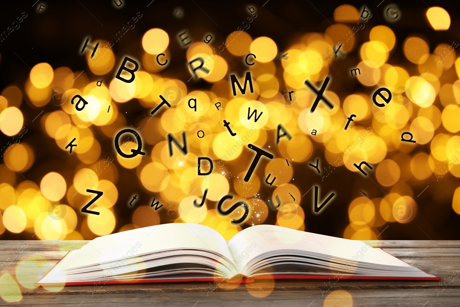 Image of Letters flying out from open book on wooden table, bokeh effect