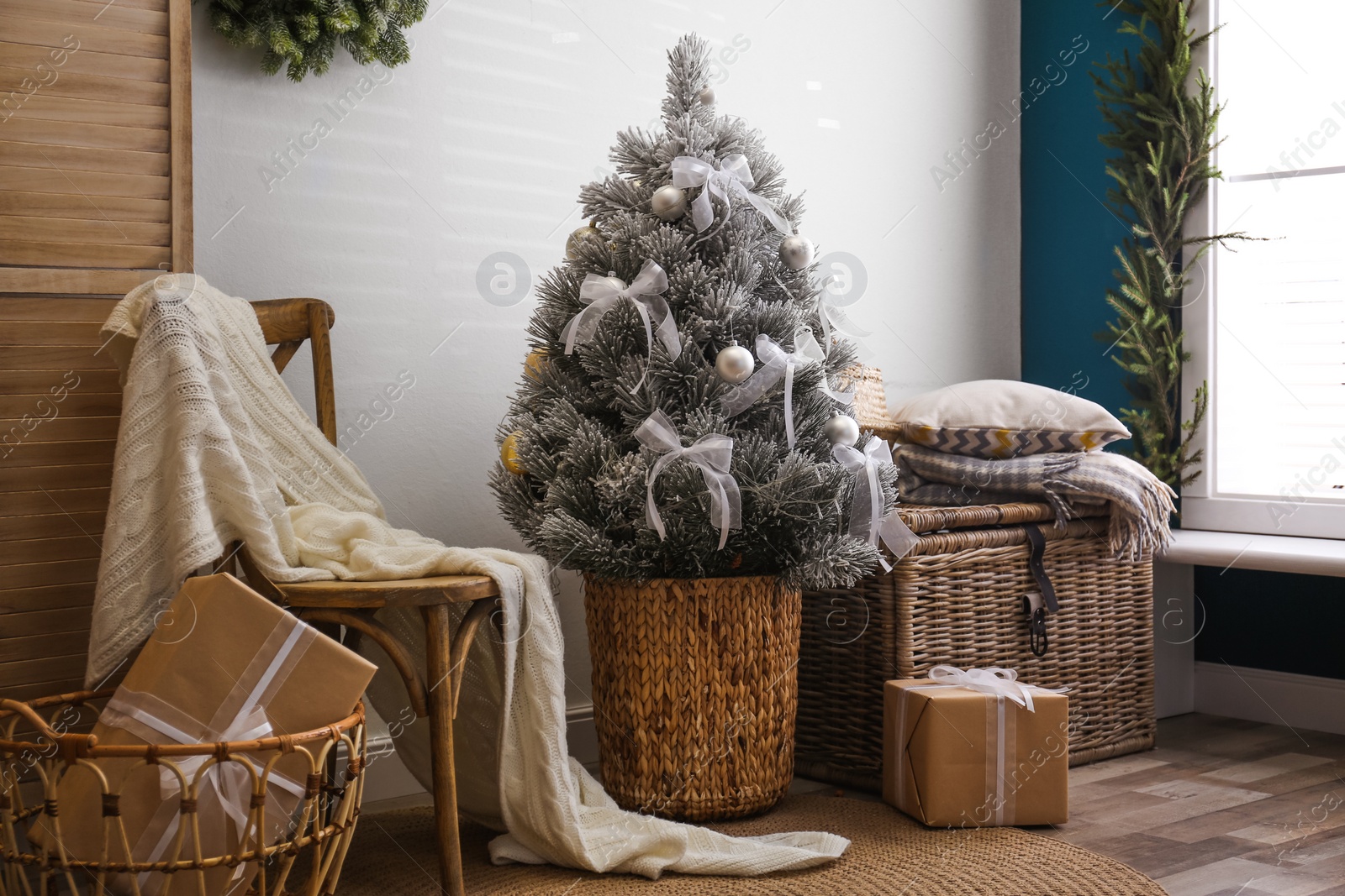 Photo of Stylish room interior with beautiful Christmas tree near white wall