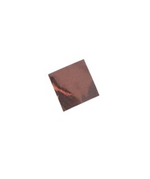 Piece of bronze confetti isolated on white