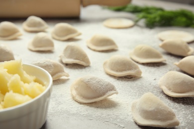 Photo of Raw dumplings on grey table, closeup. Process of cooking