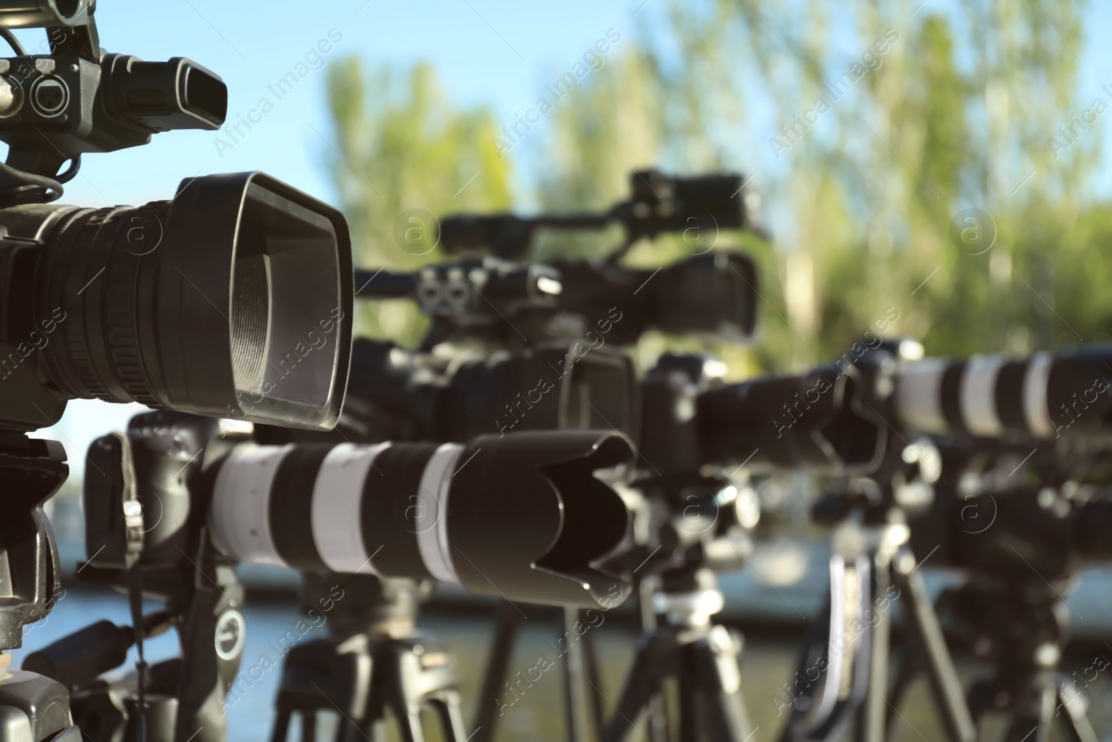 Photo of Modern professional video cameras outdoors on sunny day, closeup