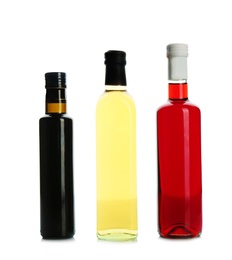 Photo of Glass bottles with different kinds of vinegar on white background