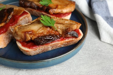 Photo of Tasty sandwiches with fried pork fatback slices on light grey table, closeup