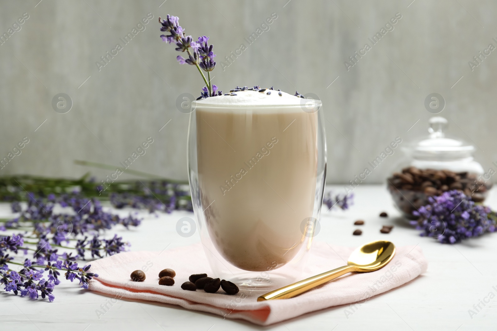 Photo of Delicious coffee with lavender and beans on white wooden table