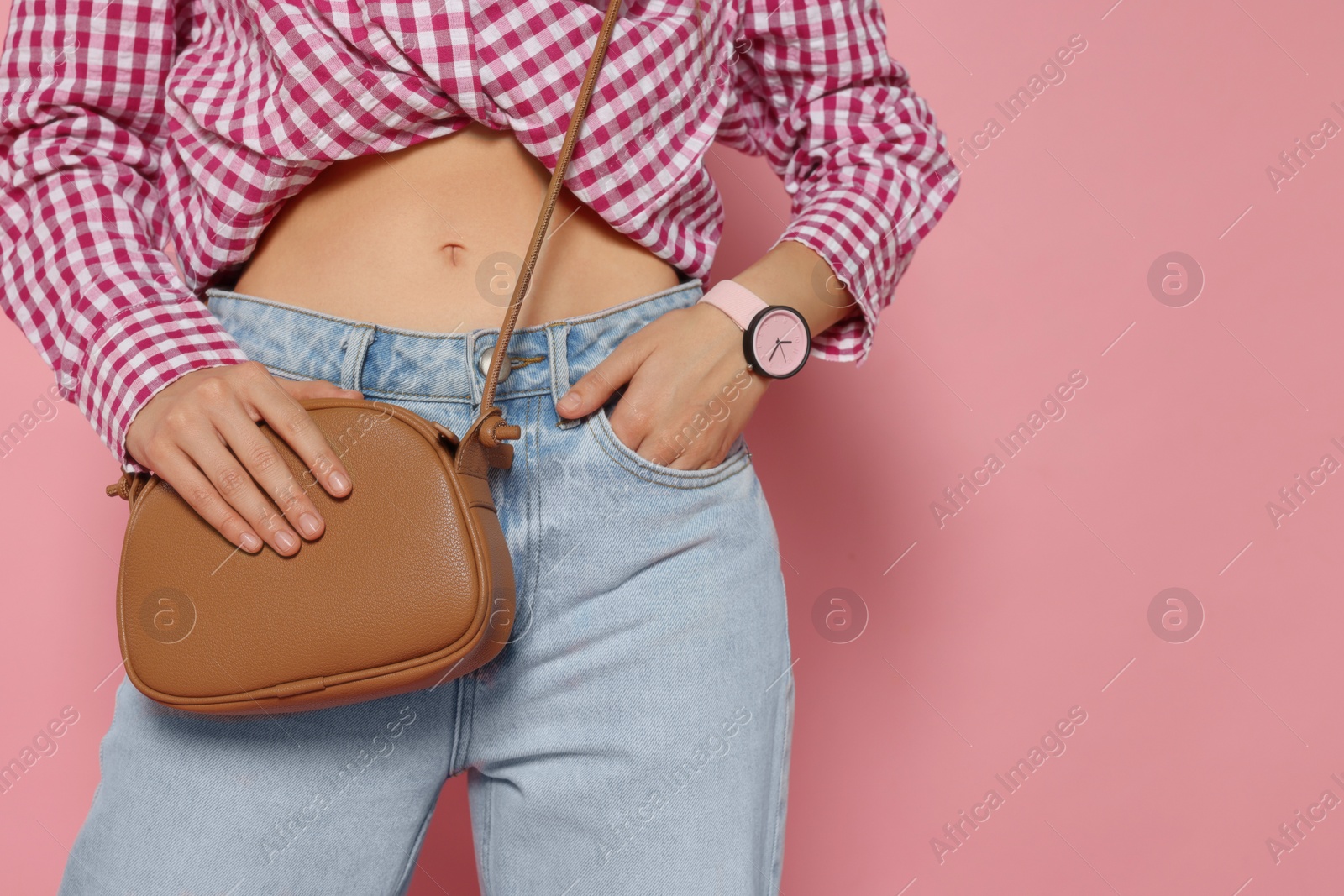 Photo of Woman in fashionable outfit with stylish bag on pink background, closeup. Space for text