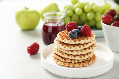 Photo of Delicious breakfast with waffles and berries on light table