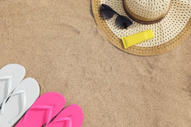 Photo of Flat lay composition with bright flip flops on sand. Space for text