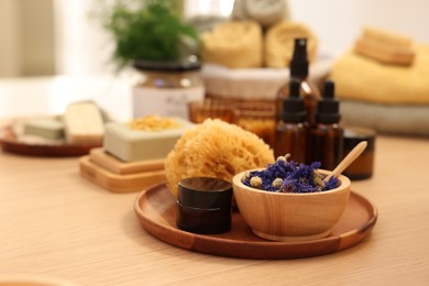 Photo of Dry flowers, loofah and jar of cream on wooden table, space for text. Spa time