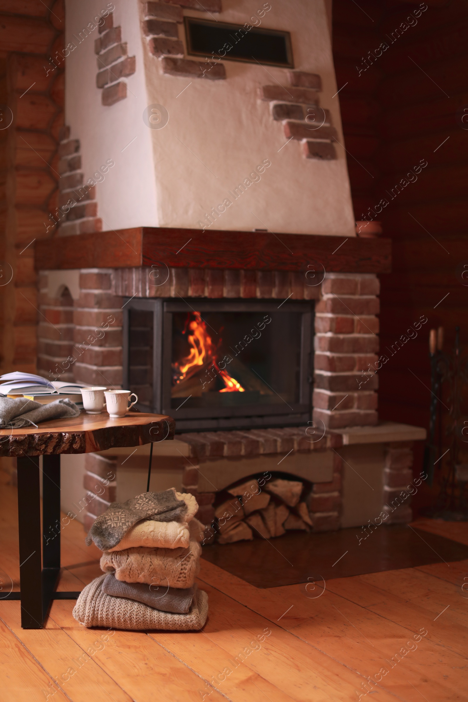 Photo of Fireplace with burning wood in room. Winter vacation