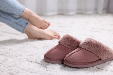 Photo of Pink soft slippers and woman at home, selective focus