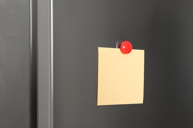 Blank note with magnet on refrigerator door. Space for text