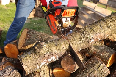 Man sawing wood on sunny day, closeup view