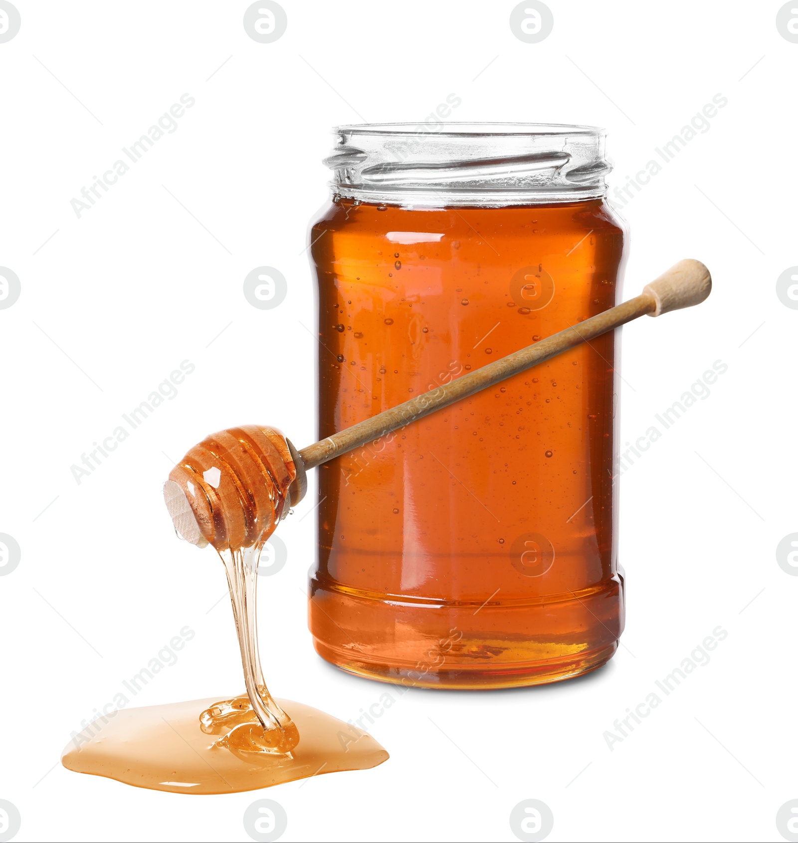 Image of Natural honey dripping from dipper. Jar full of honey on white background