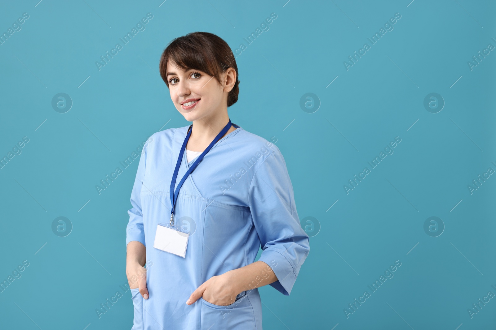 Photo of Portrait of smiling medical assistant on light blue background. Space for text