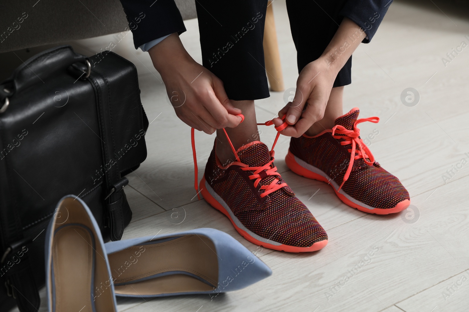 Photo of Woman changing shoes on sofa in office, closeup