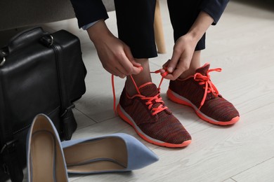 Photo of Woman changing shoes on sofa in office, closeup