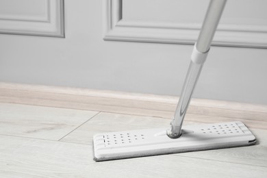 Photo of Cleaning of parquet floor with mop indoors. Space for text