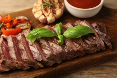 Delicious grilled beef steak with spices and tomato sauce on table, closeup