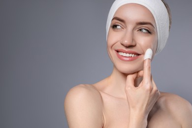 Photo of Woman using silkworm cocoon in skin care routine on grey background. Space for text