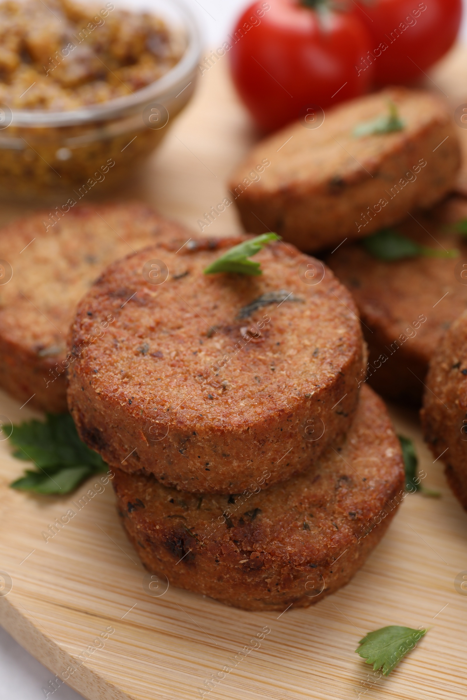 Photo of Tasty vegan cutlets on wooden board, closeup