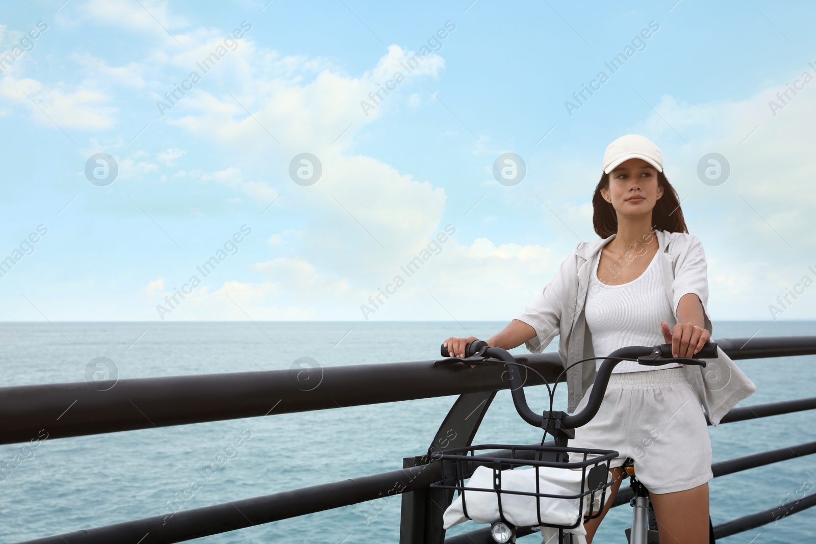 Photo of Beautiful young woman with bicycle near sea. Space for text