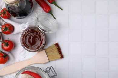 Photo of Marinade in jar, ingredients and basting brush on white tiled table, flat lay. Space for text