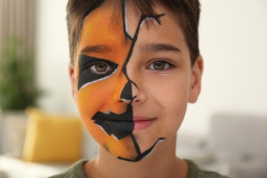 Photo of Cute little boy with face painting indoors, closeup