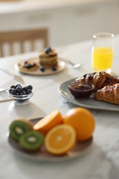 Tasty breakfast. Fresh croissants with jam on white marble table, selective focus