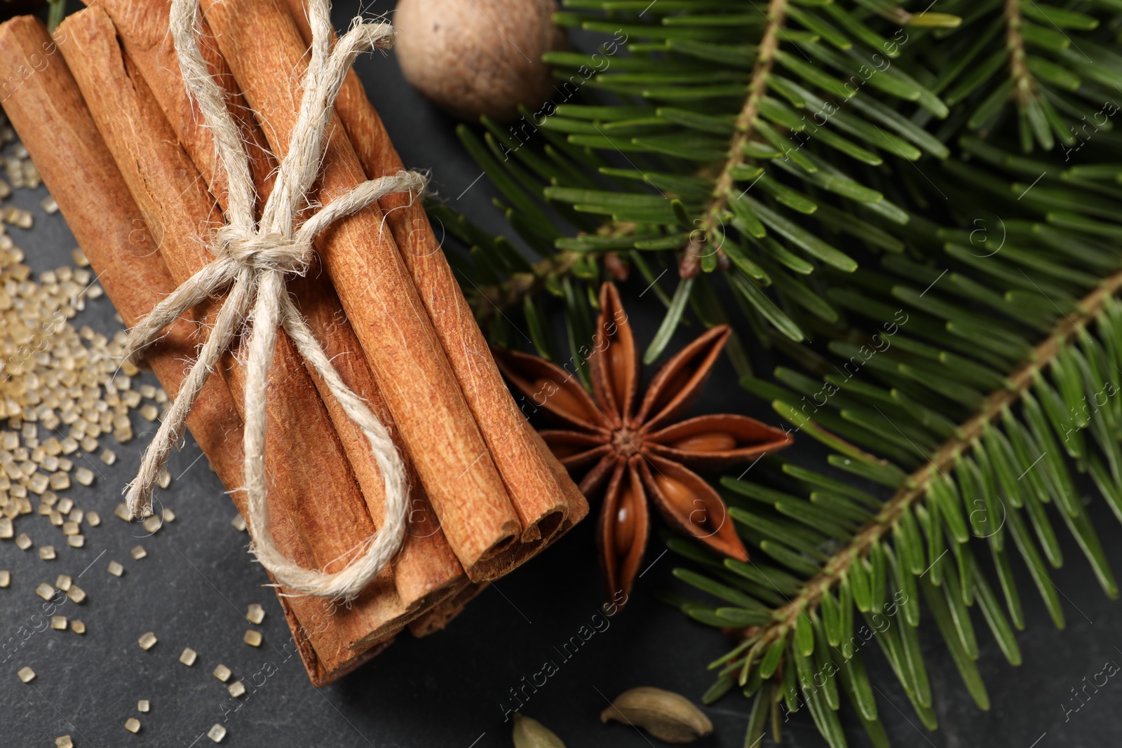 Photo of Different spices and fir branches on gray table, flat lay