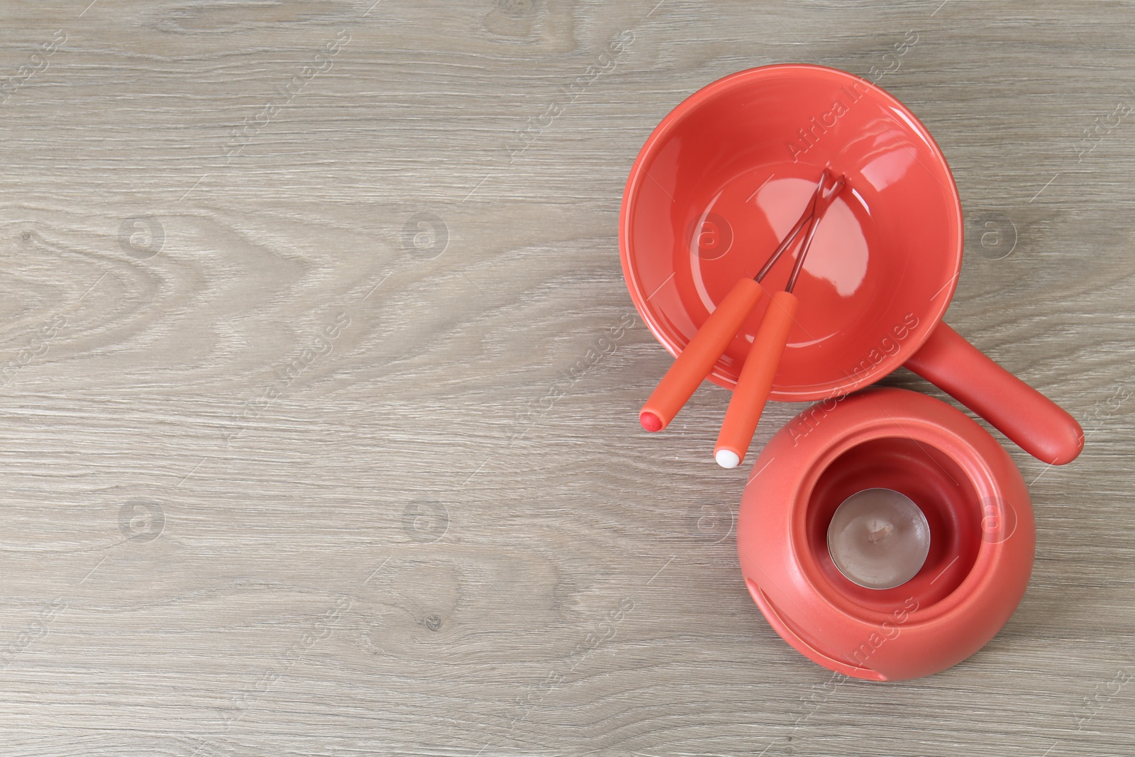 Photo of Fondue set on wooden table, flat lay. Space for text