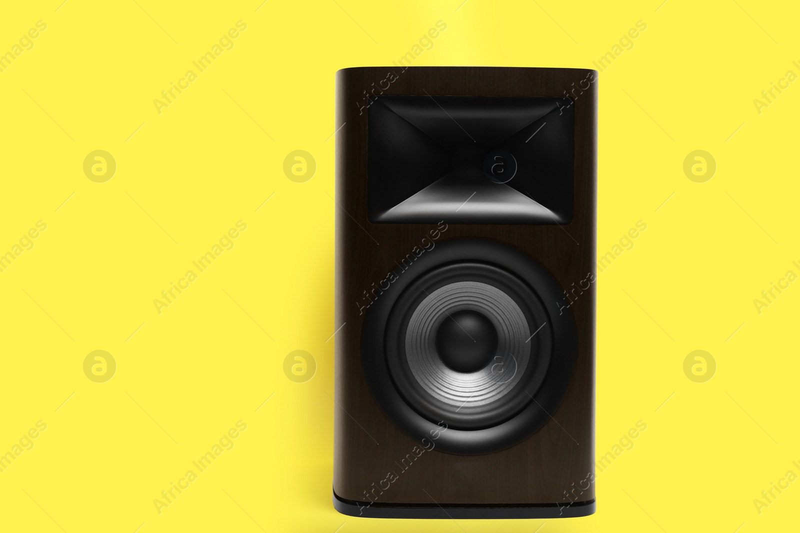 Photo of One wooden sound speaker on yellow background. Space for text