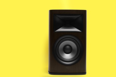 Photo of One wooden sound speaker on yellow background. Space for text