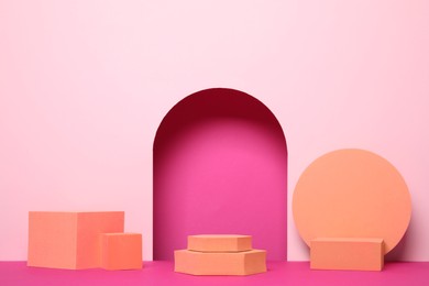 Many orange geometric figures on pink background. Stylish presentation for product