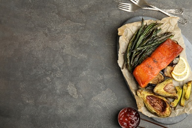 Photo of Tasty cooked salmon and vegetables served on grey table, flat lay with space for text. Healthy meals from air fryer