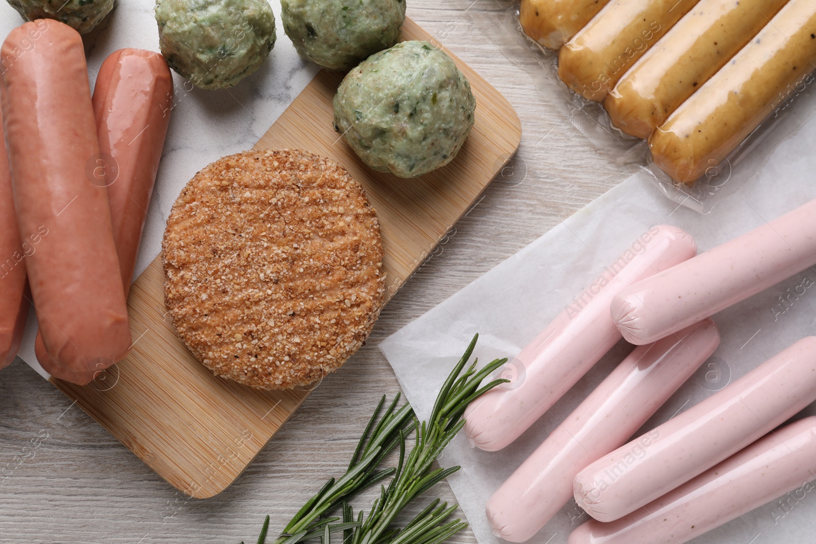 Photo of Different vegan products and rosemary on white wooden table, flat lay