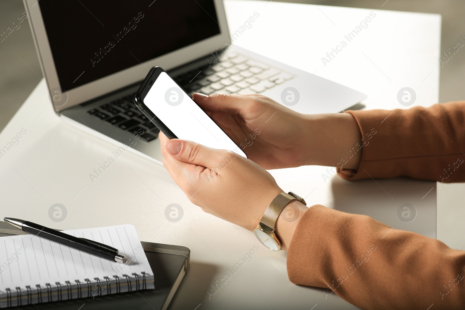 Photo of Woman using smartphone at white table, closeup