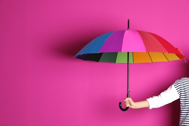 Photo of Woman holding beautiful umbrella on color background with space for design