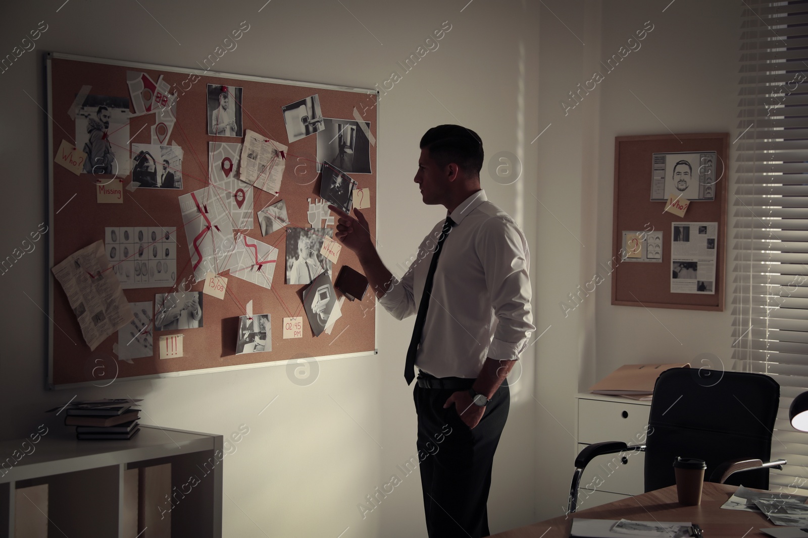 Photo of Detective looking at evidence board in office