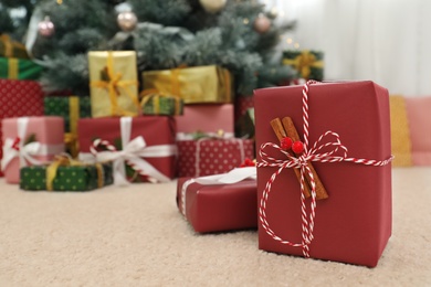 Photo of Beautiful Christmas gift and blurred pile of presents on background. Space for text