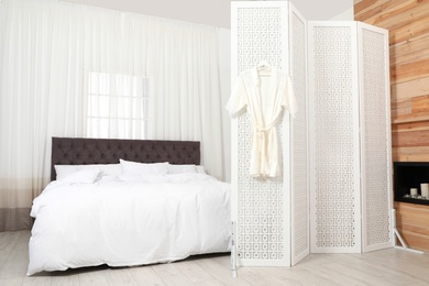 Modern folding screen in stylish bedroom interior
