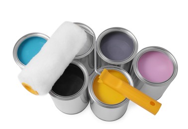 Photo of Cans with different paints and roller on white background