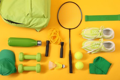 Different sports equipment on yellow background, flat lay