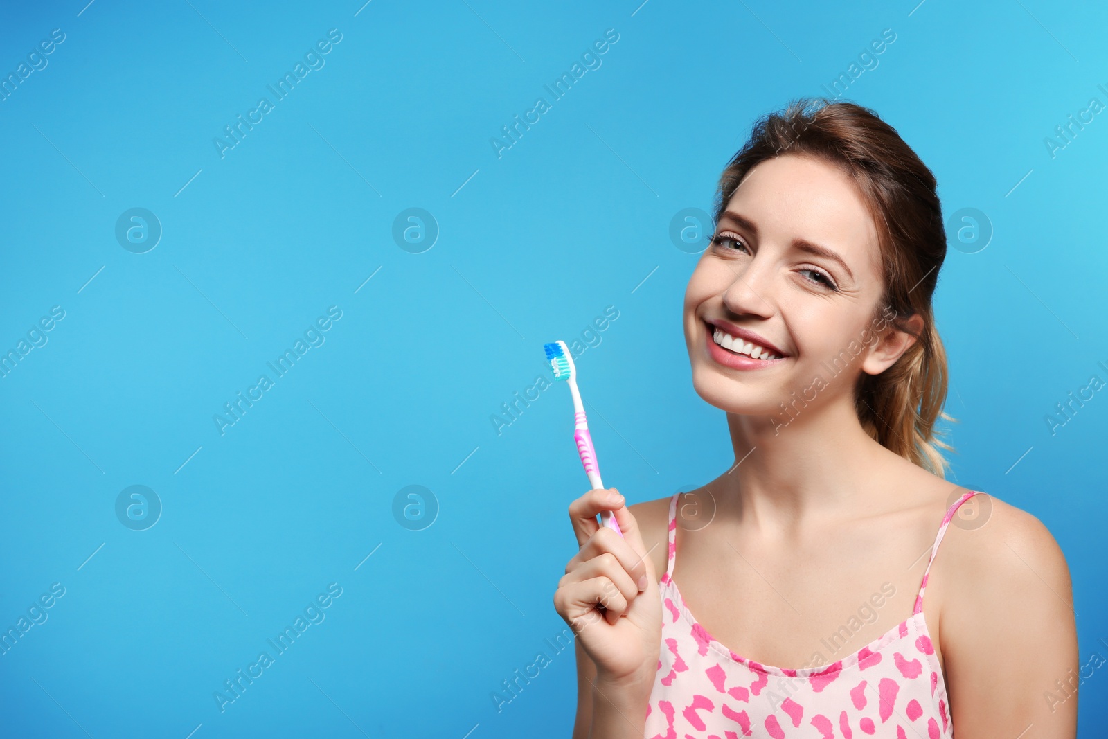 Photo of Portrait of young woman with toothbrush on color background. Space for text