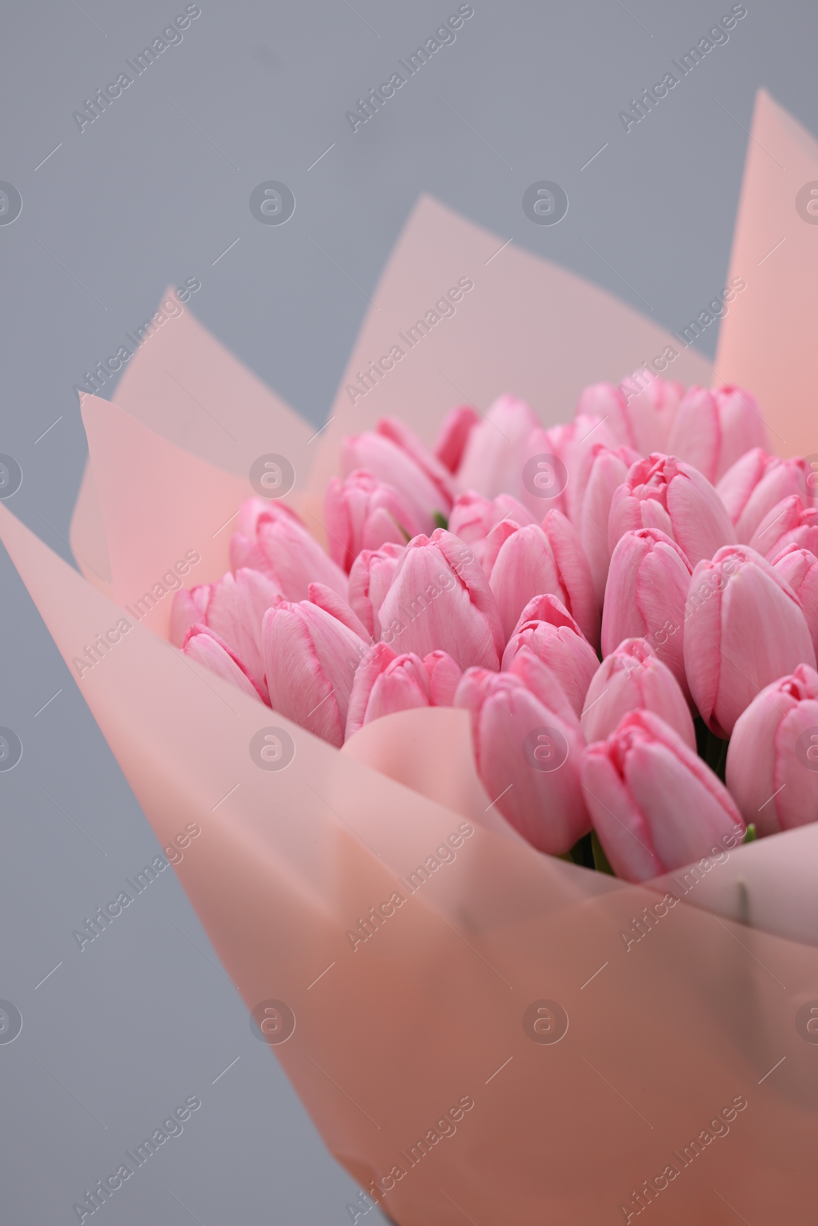 Photo of Bouquet of beautiful pink tulips on light grey background, closeup