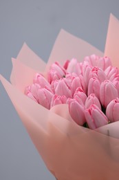 Photo of Bouquet of beautiful pink tulips on light grey background, closeup