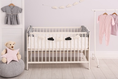 Photo of Stylish baby room interior with comfortable crib