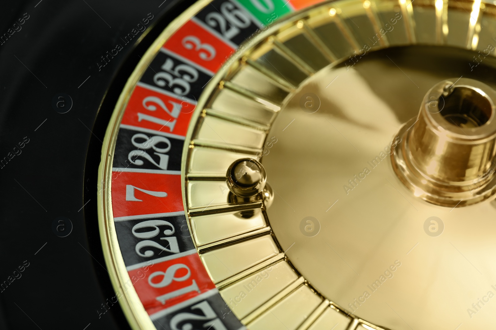 Photo of Roulette wheel with ball, closeup. Casino game