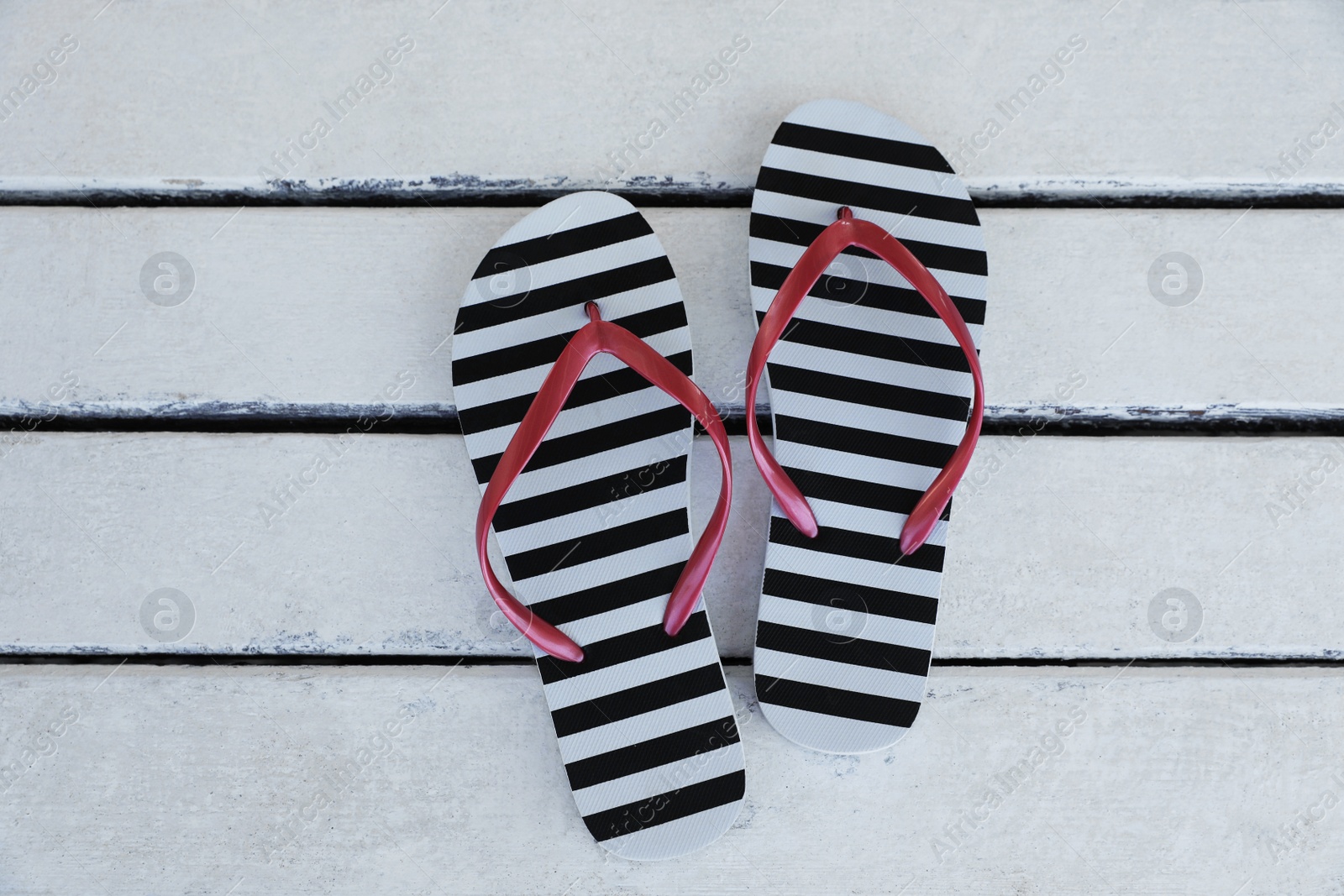 Photo of Stylish flip flops on white wooden table, flat lay