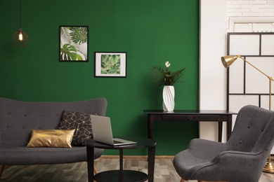 Photo of Modern living room interior stylish sofa near green wall